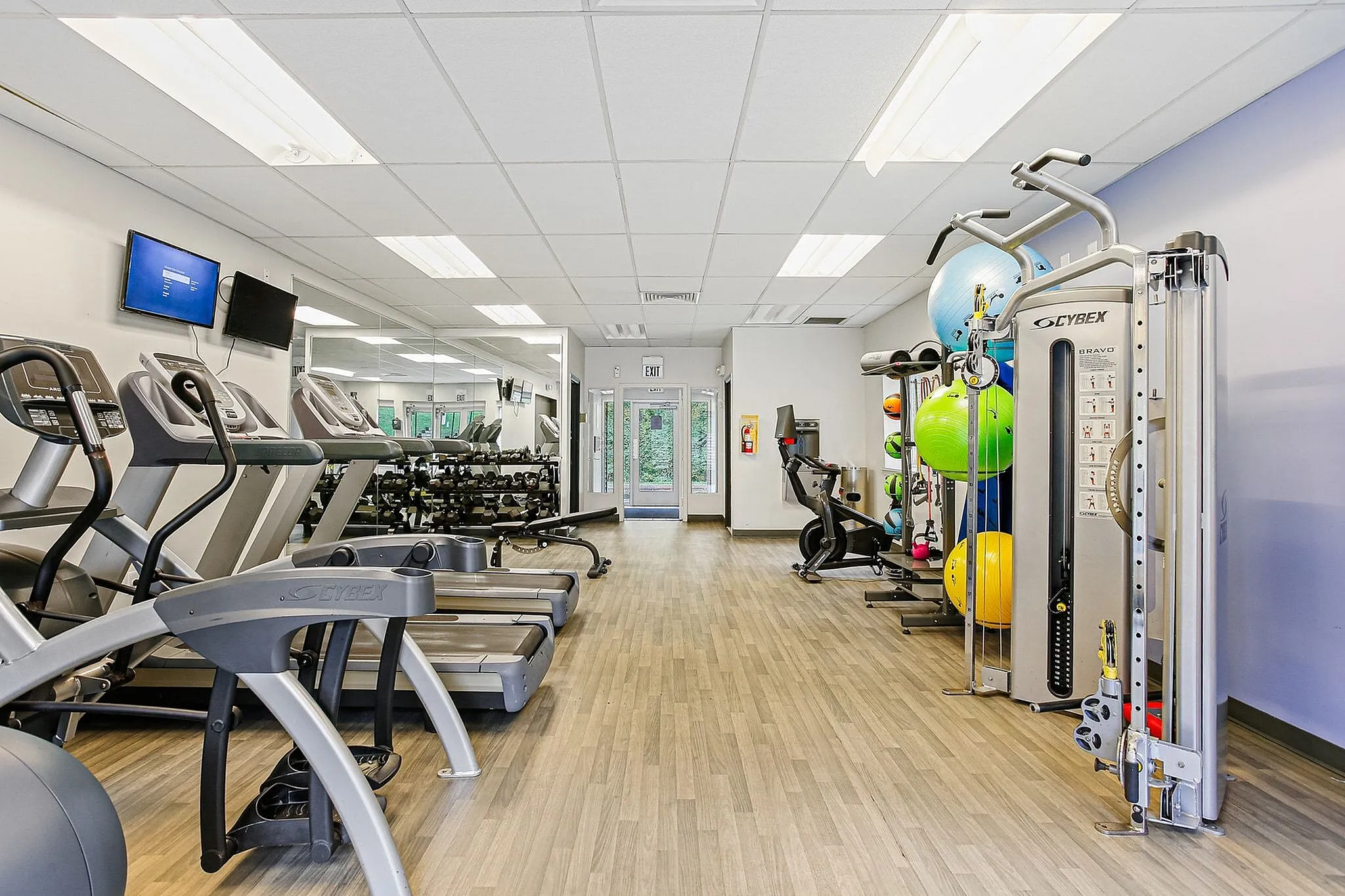 Modern and well-equipped gym with state-of-the-art exercise machines and vibrant workout balls, perfect for an active lifestyle.