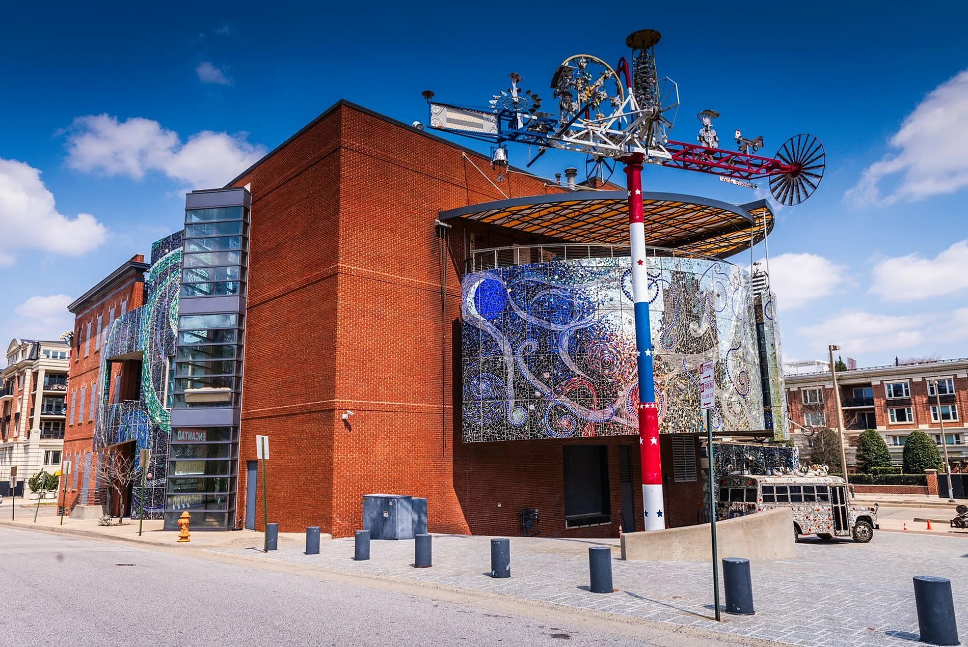 Vibrant urban building with a stunning mosaic facade and modern architectural design under a clear blue sky.