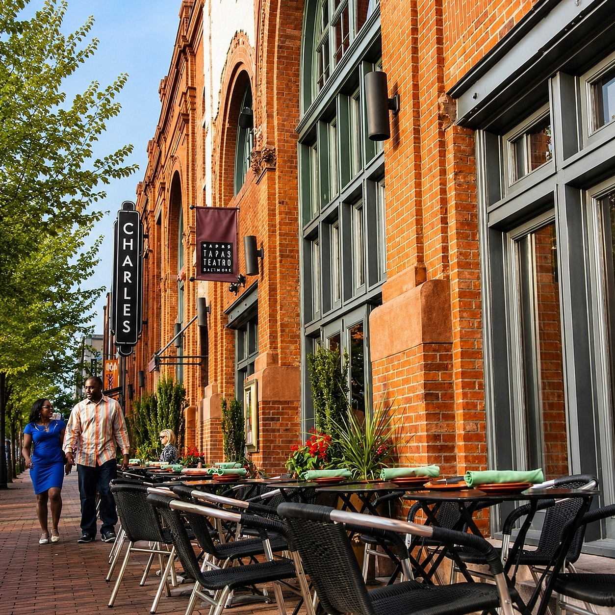 Charming street view of a vibrant urban setting with outdoor dining in front of a historic red brick building.