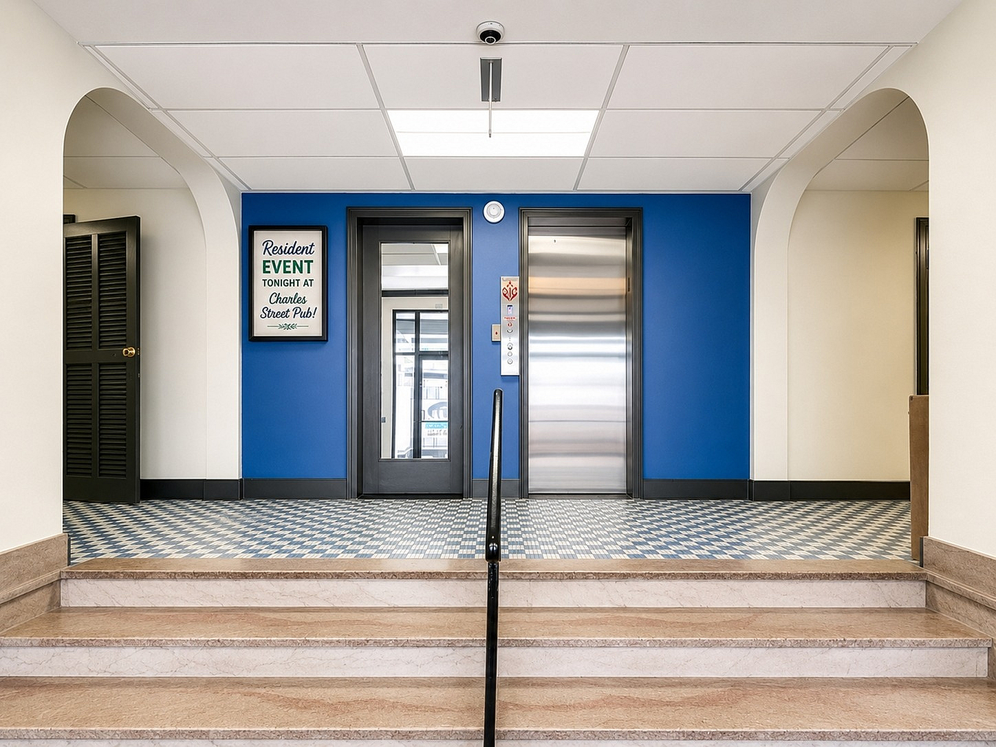 Elegant apartment entrance with stylish blue accent wall and modern elevators, inviting ambiance enhanced by warm lighting.