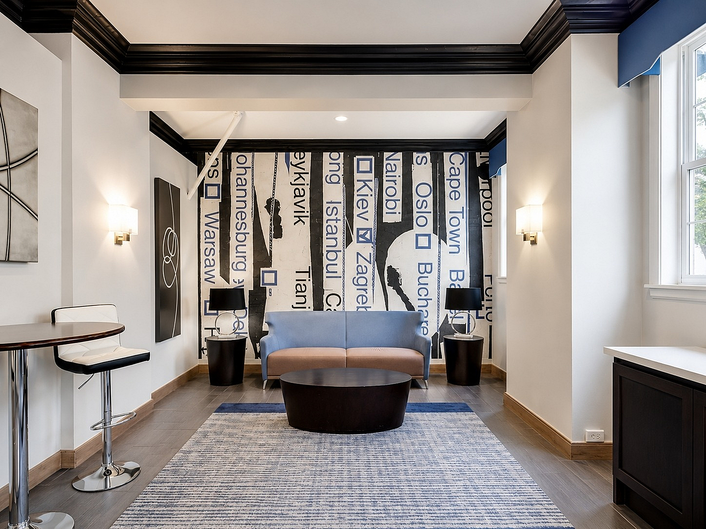 Contemporary lounge area with chic city-themed mural, stylish seating, and modern decor in a bright, inviting space.