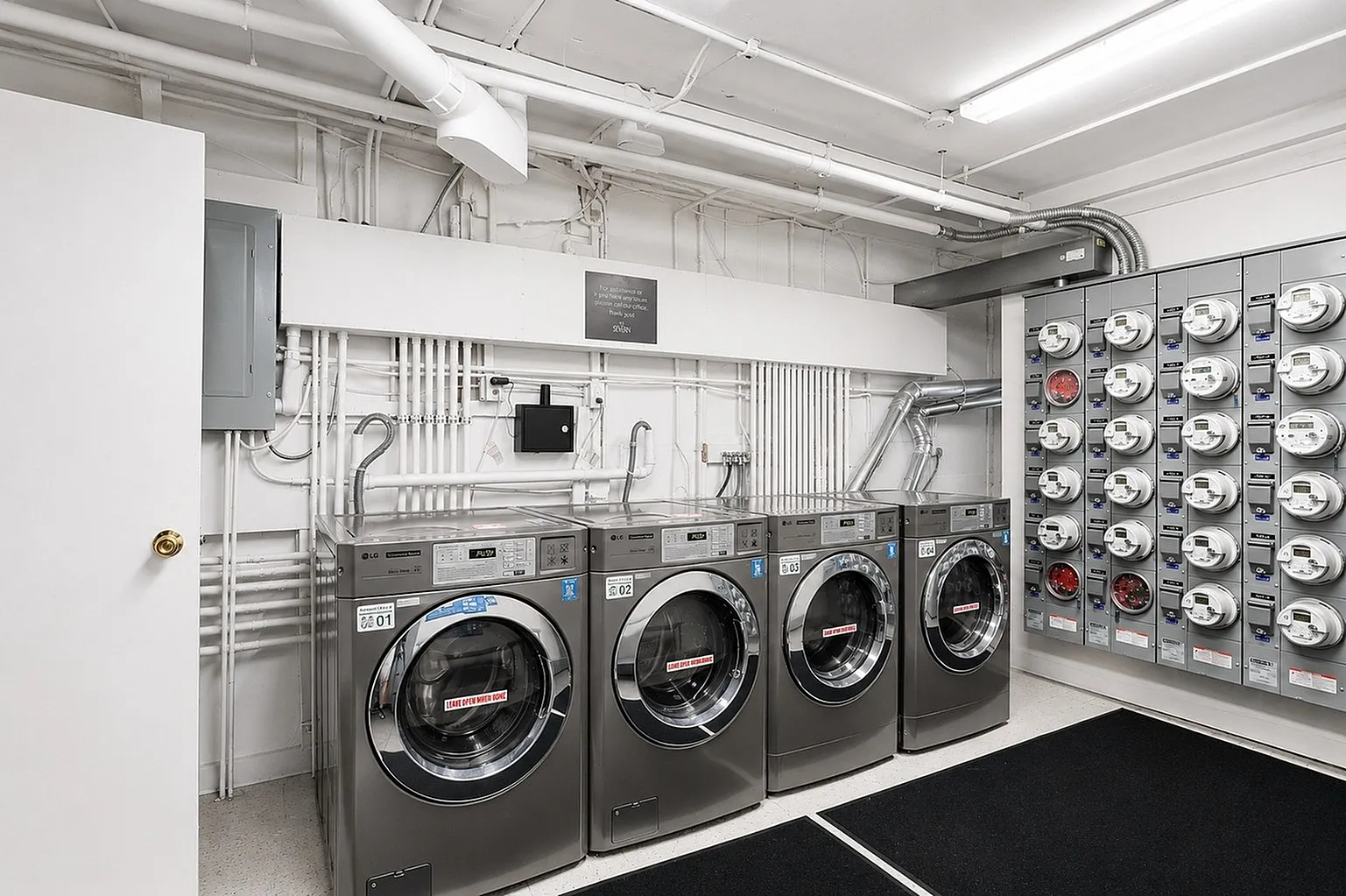 Modern laundry room equipped with stainless steel washing machines and an organized utility panel, offering convenience and efficiency.