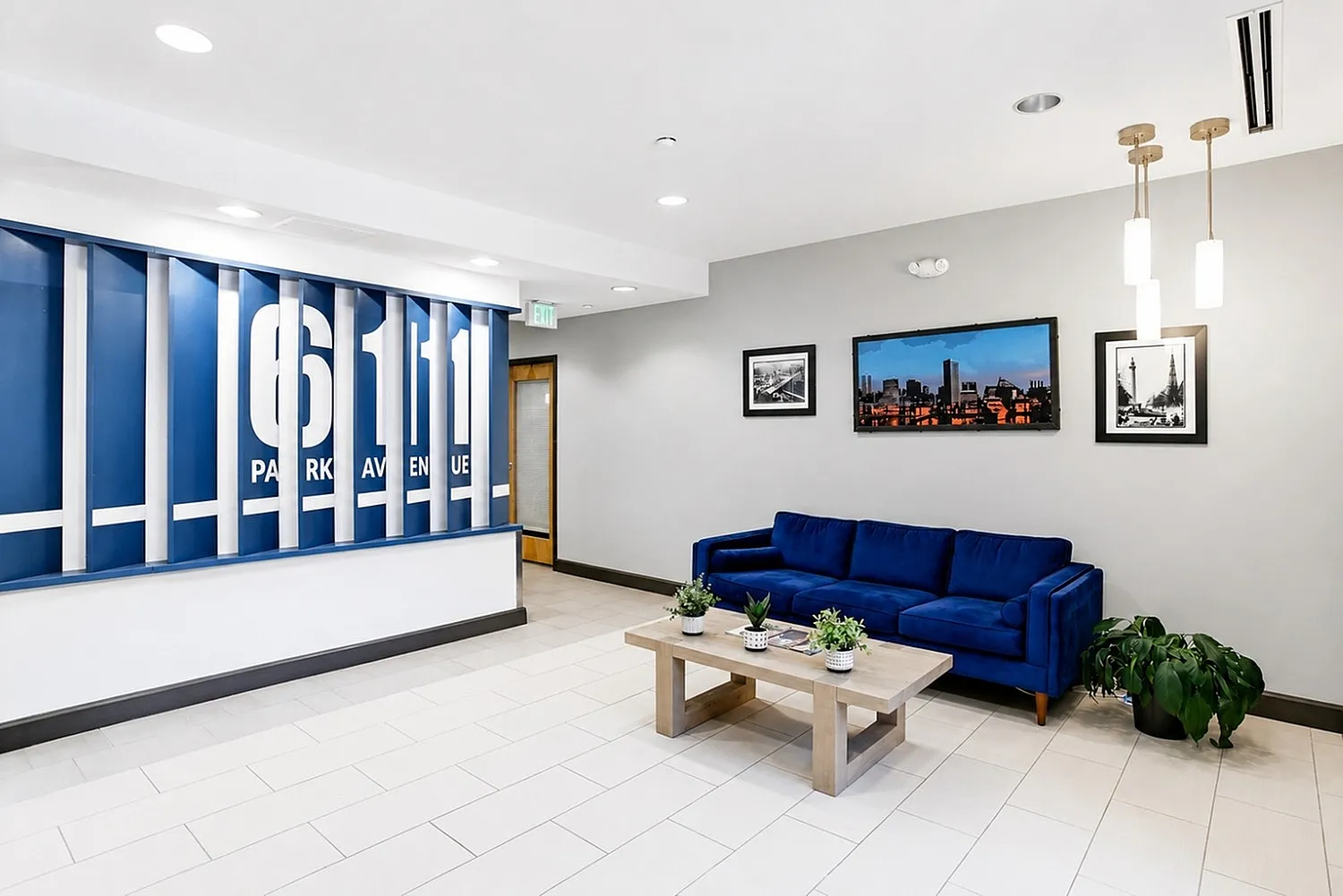 Modern apartment lobby featuring elegant decor, a vibrant blue sofa, and chic wall art at 6111 Park Avenue.