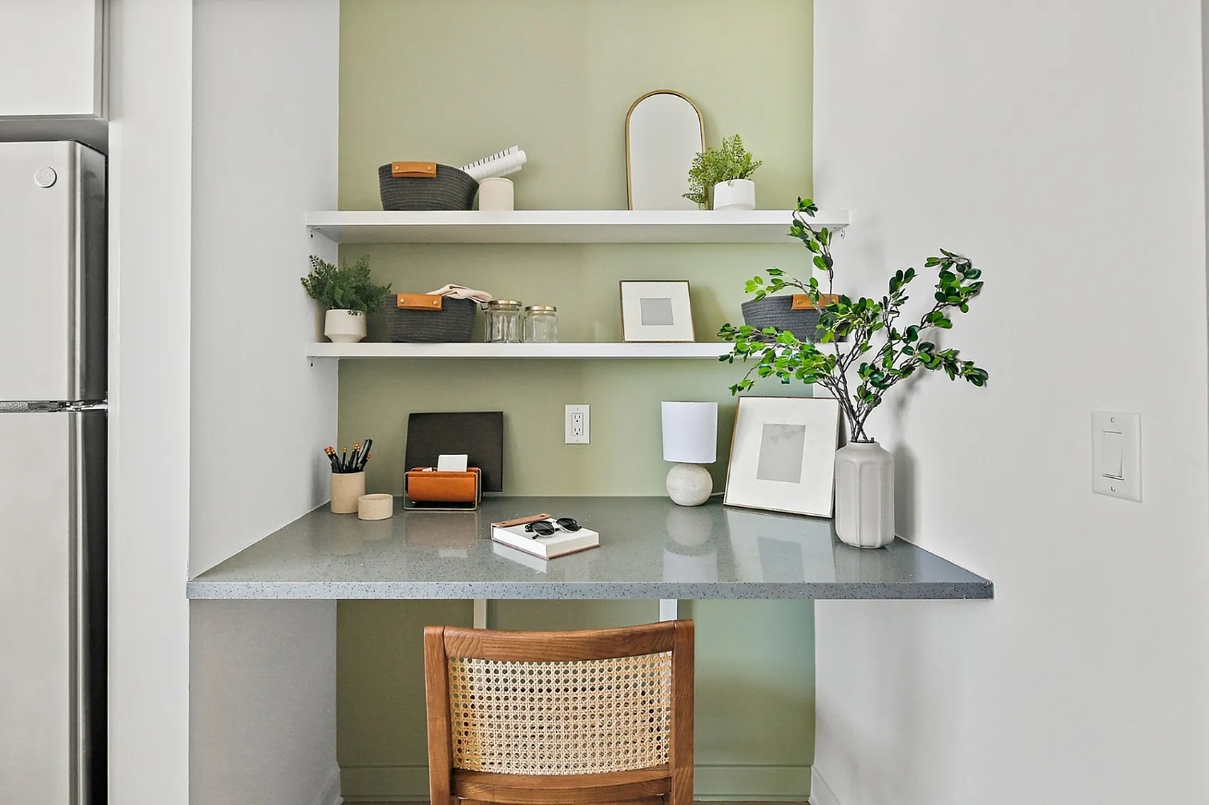 Charming home office nook with sleek desk, stylish shelving, and vibrant green accents, thoughtfully designed for productivity and style.