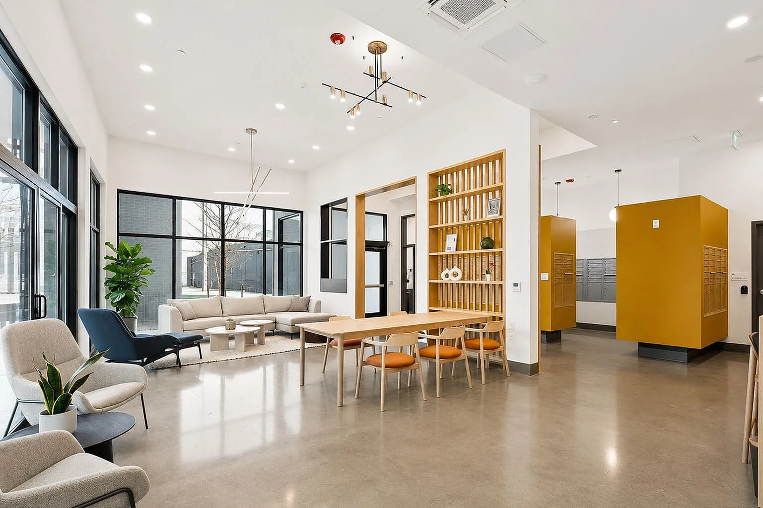 Contemporary apartment lobby with stylish seating, modern lighting, and large windows inviting natural light.