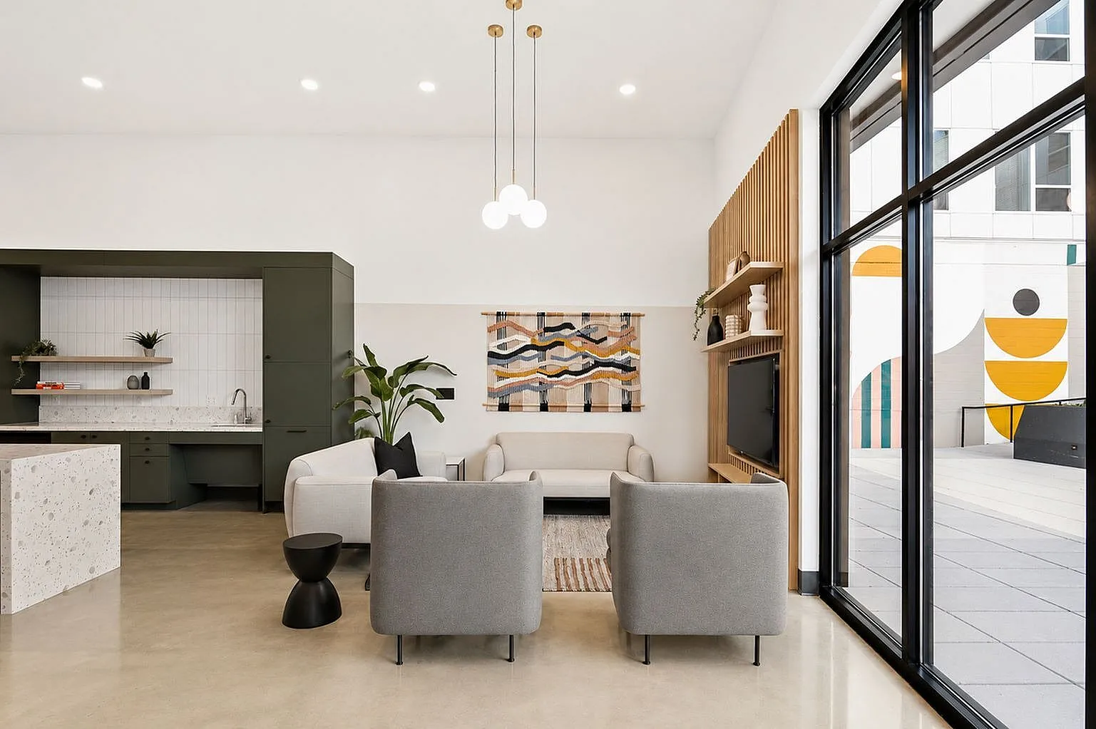 Modern living space with sleek furniture, artistic decor, and floor-to-ceiling windows offering abundant natural light.
