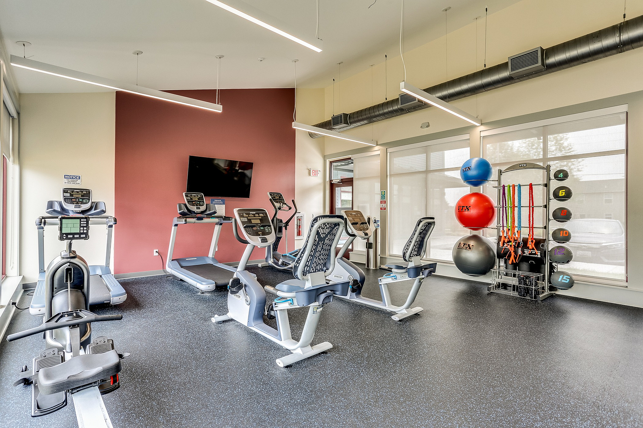 Inviting and modern fitness center featuring state-of-the-art treadmills, exercise bikes, and vibrant workout accessories.