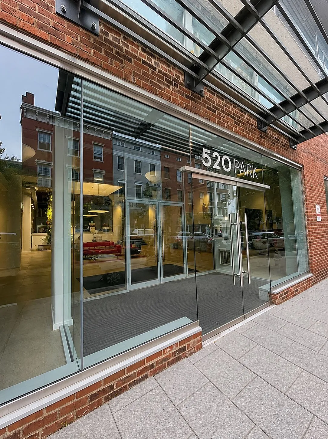 Modern building entrance featuring expansive glass windows and stylish brick facade at 520 Park.