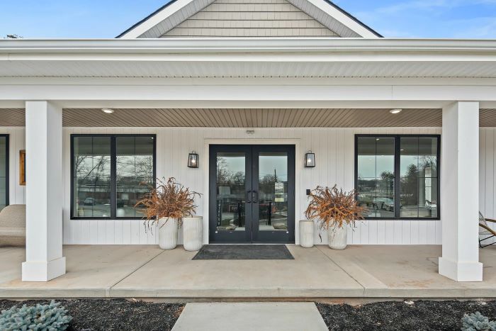 The resident clubhouse at Emerson Flats. Inviting white-trimmed front porch with white siding, cozy and welcoming.