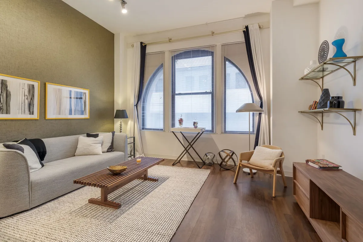 Modern living room with stylish furniture and large arched window for natural light