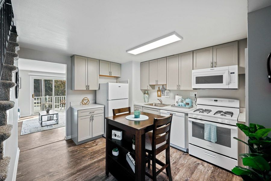 Charming apartment kitchen with modern appliances, stylish cabinetry, and an inviting dining area showcasing elegant hardwood floors.