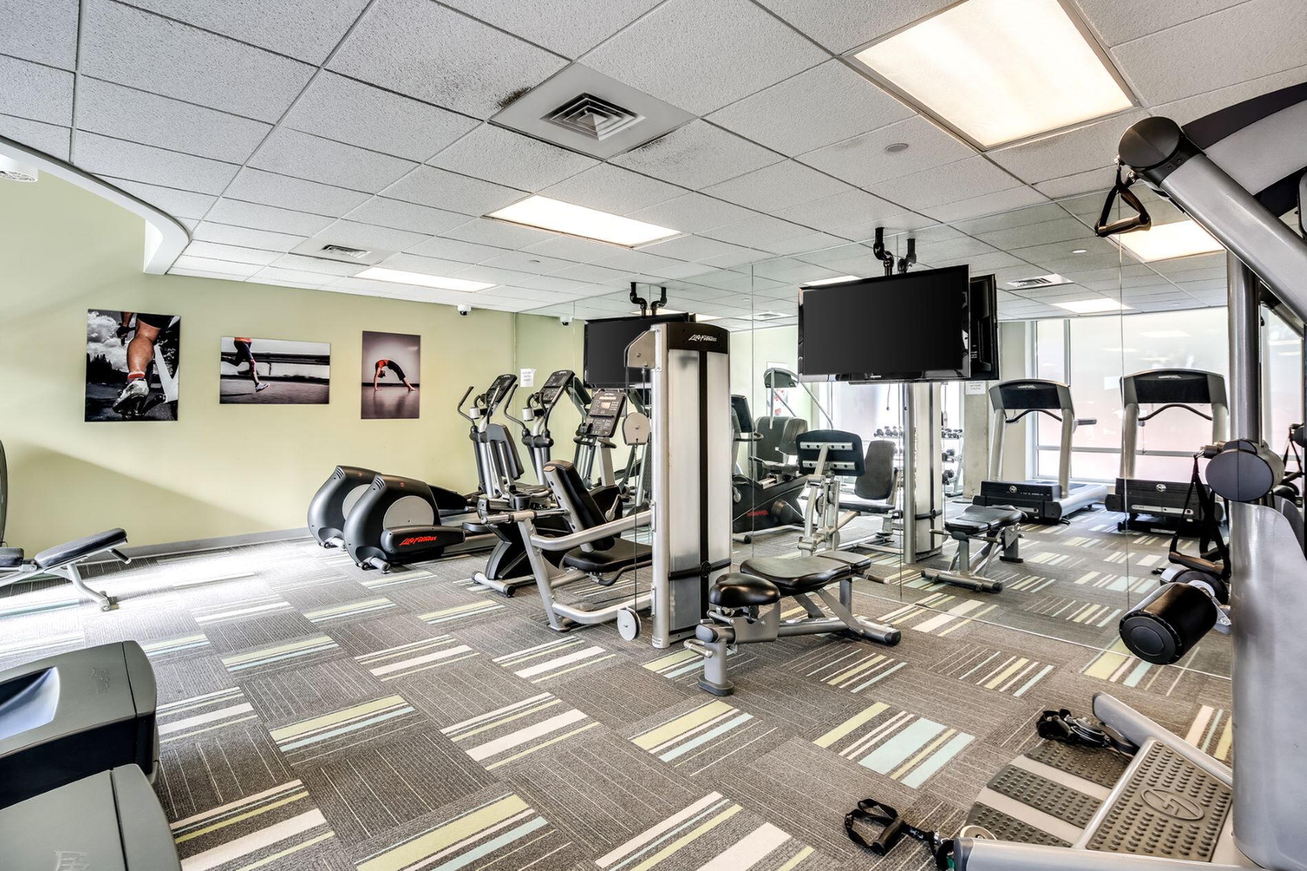 Modern gym with state-of-the-art exercise equipment, bright lighting, and motivational artwork on the walls.