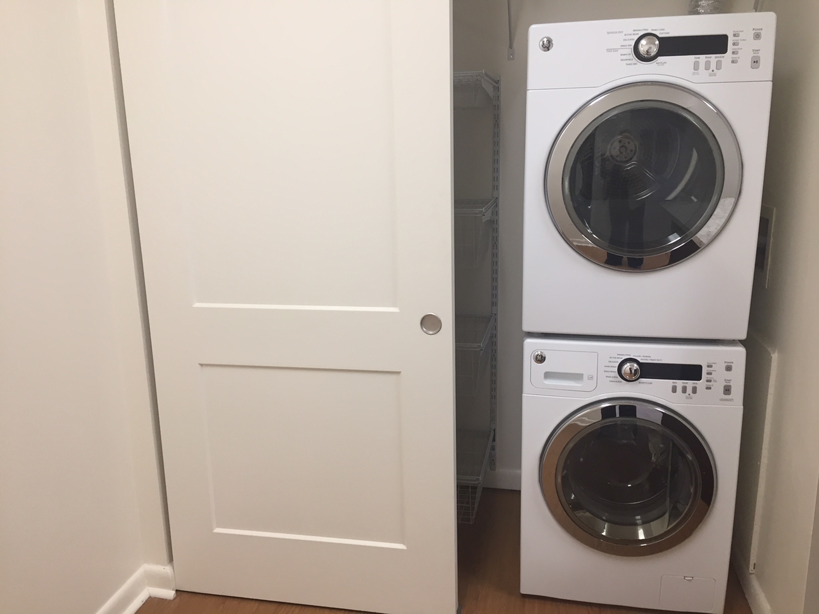 Modern laundry area featuring sleek, stackable washer and dryer with efficient sliding door design.