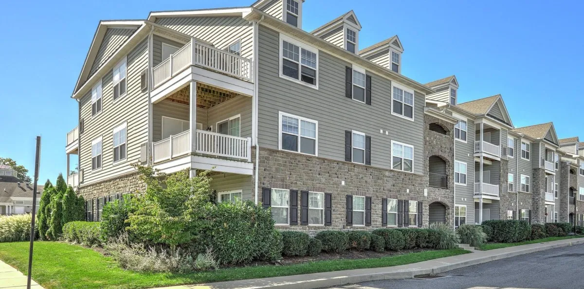 Exterior view of apartments with bricks, shudders, and balconies.