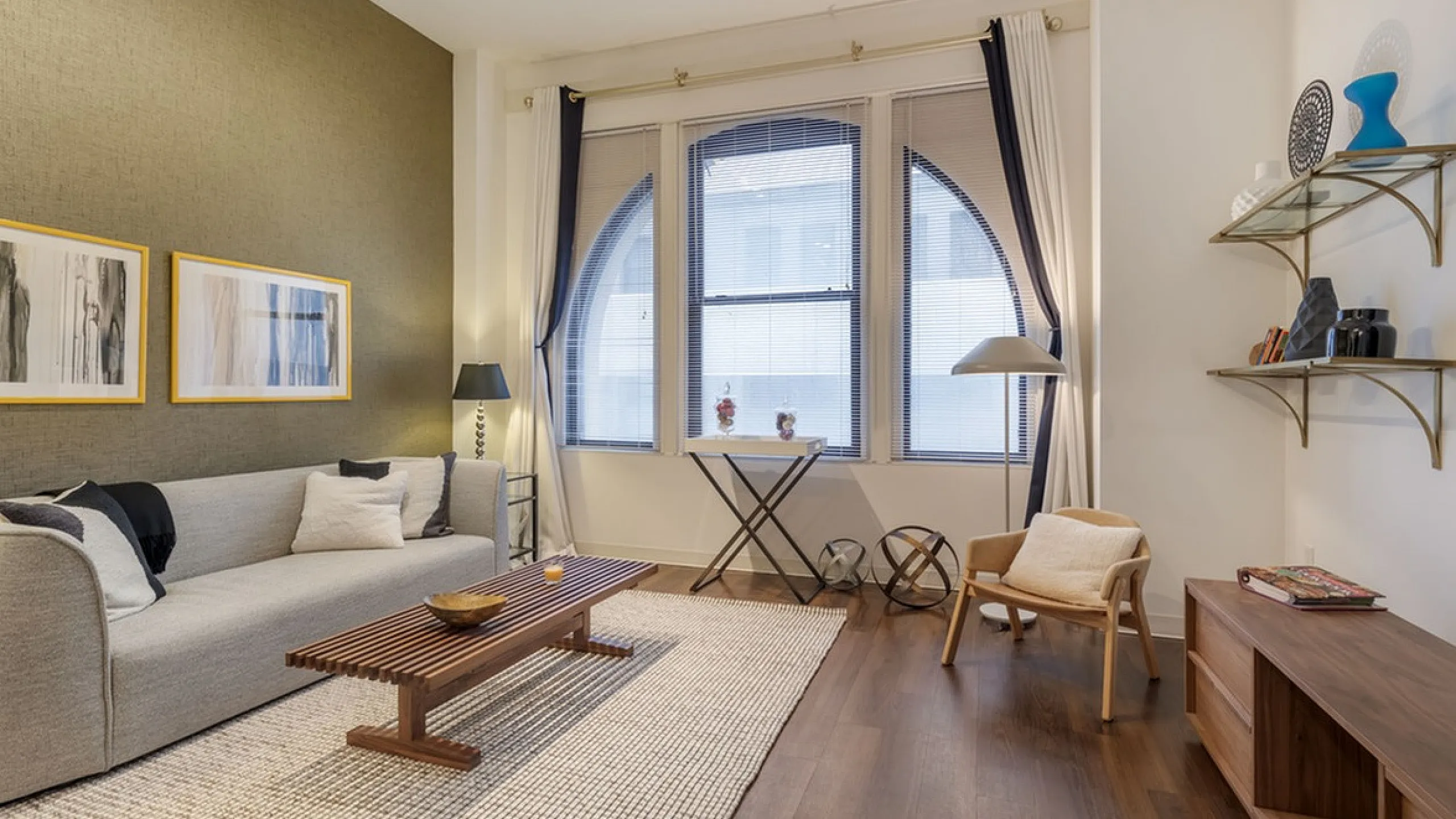 Modern apartment living room with stylish furniture and large window.