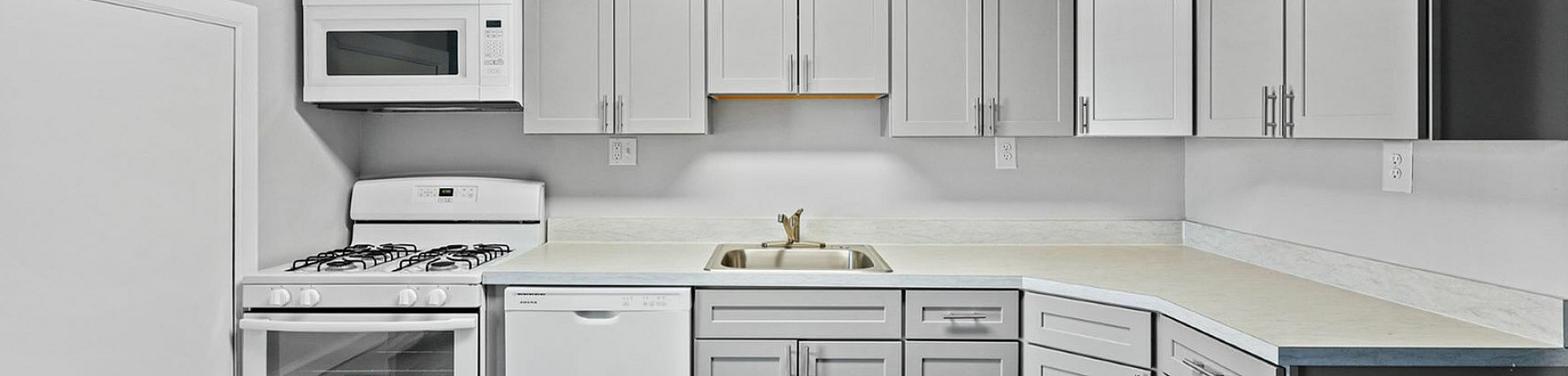 Bright modern kitchen with sleek gray cabinets, white appliances, and hardwood floors