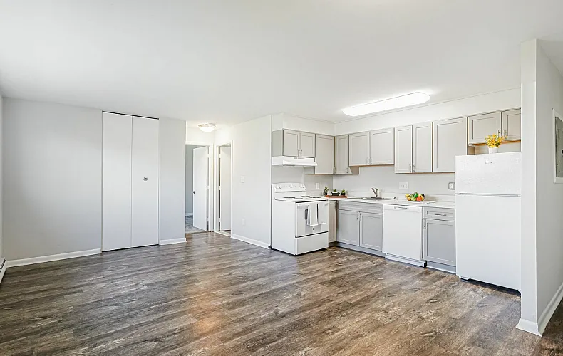 Bright and inviting kitchen with modern white cabinetry, sleek appliances, and elegant wood flooring.