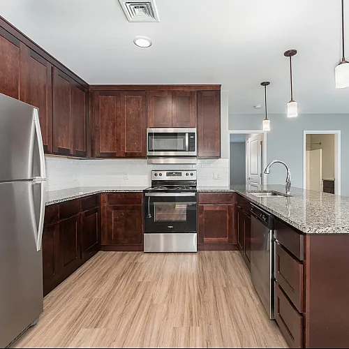 Modern kitchen with elegant wooden cabinets, stainless steel appliances, and a stylish granite countertop island, perfect for entertaining.