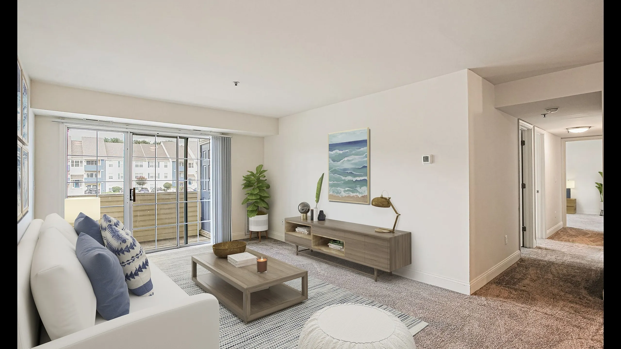 Bright and inviting living room with modern furnishings, showcasing a cozy seating area, stylish decor, and large sliding doors opening to a scenic balcony view.