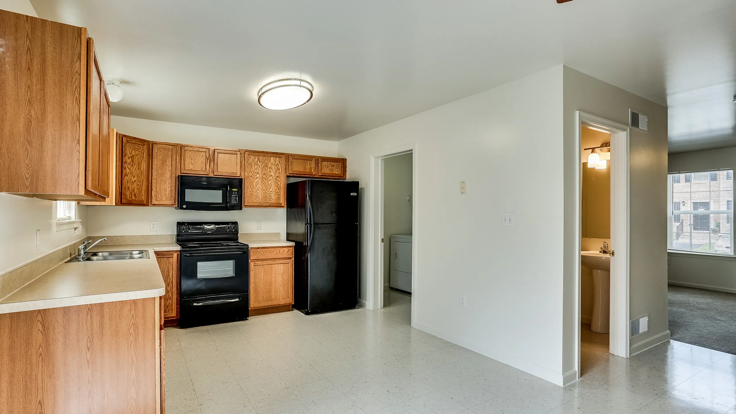Bright and welcoming kitchen with modern appliances, ample cabinetry, and adjacent living area, perfect for comfortable living.
