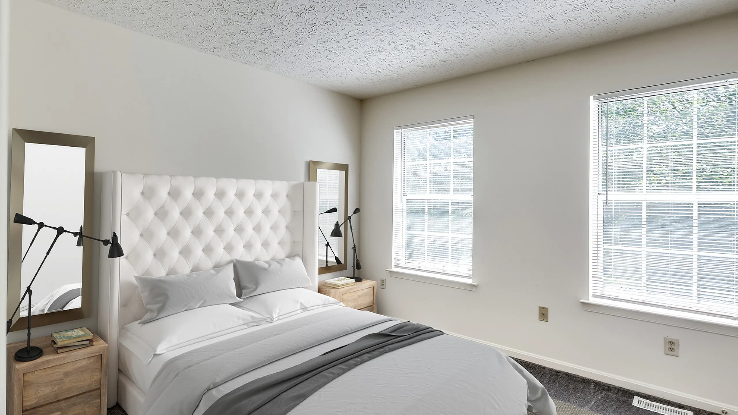 Bright and inviting bedroom featuring a plush tufted headboard, elegant bedside tables, and large windows providing natural light.