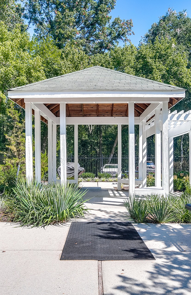 Inviting outdoor space featuring a charming gazebo, lush greenery, and modern patio seating for relaxation.