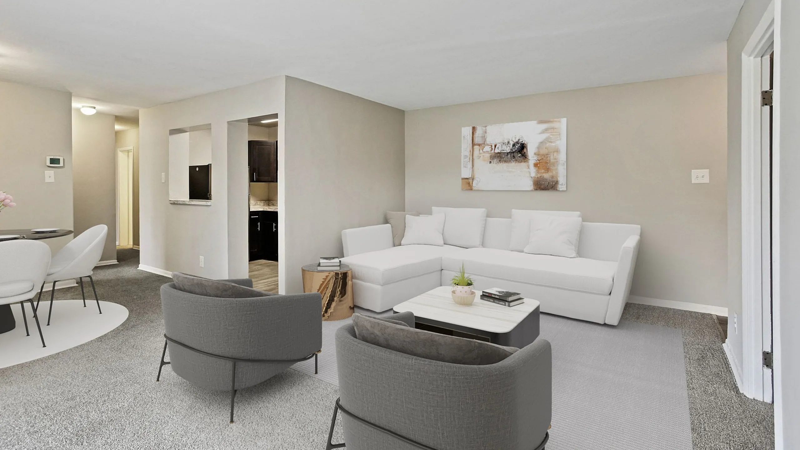Contemporary open-plan living and dining area with sleek furnishings, soft carpeting, and a view into a modern kitchen.