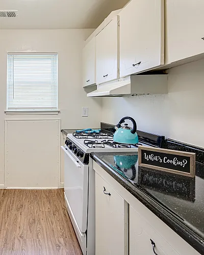 Charming galley kitchen with white cabinetry, sleek countertops, and a cozy cooking atmosphere.