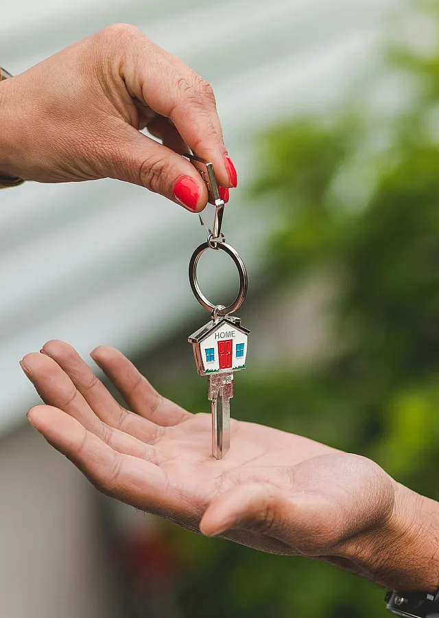 Symbolic image of new beginnings with a key handover, highlighting the excitement of acquiring a new home.