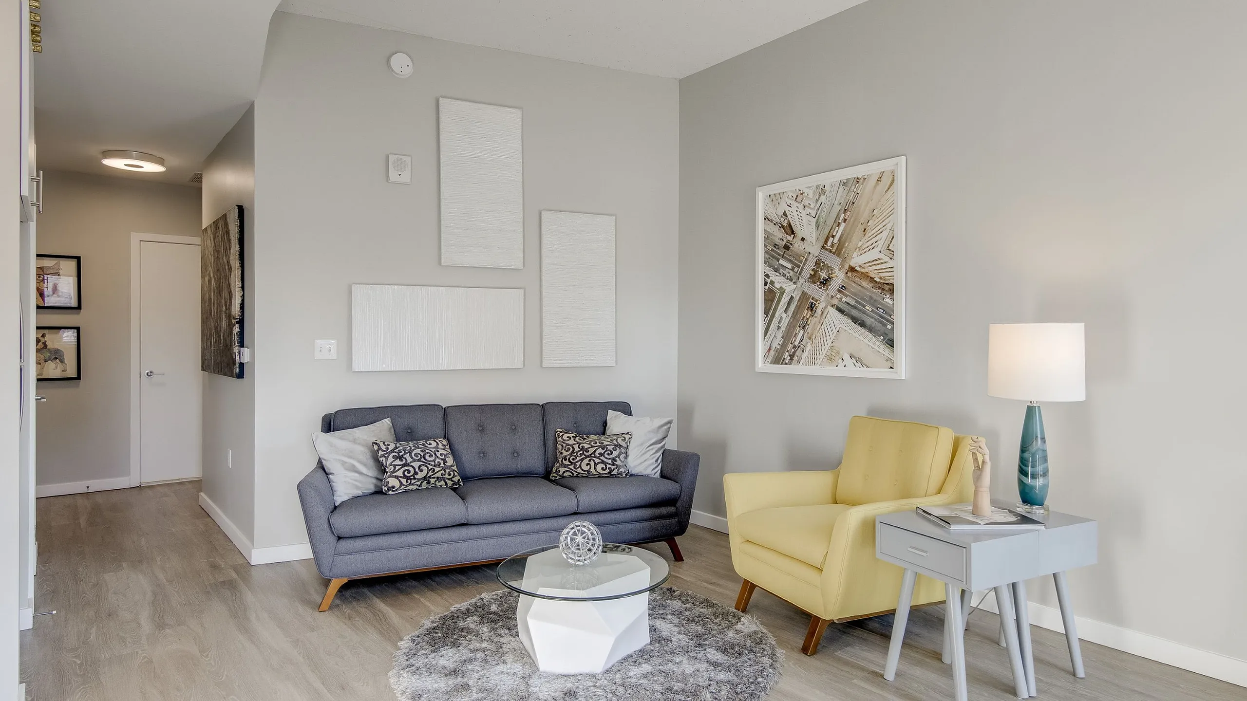 Cozy modern living room with stylish gray sofa, vibrant yellow armchair, and chic decor elements, perfect for relaxation and comfort.