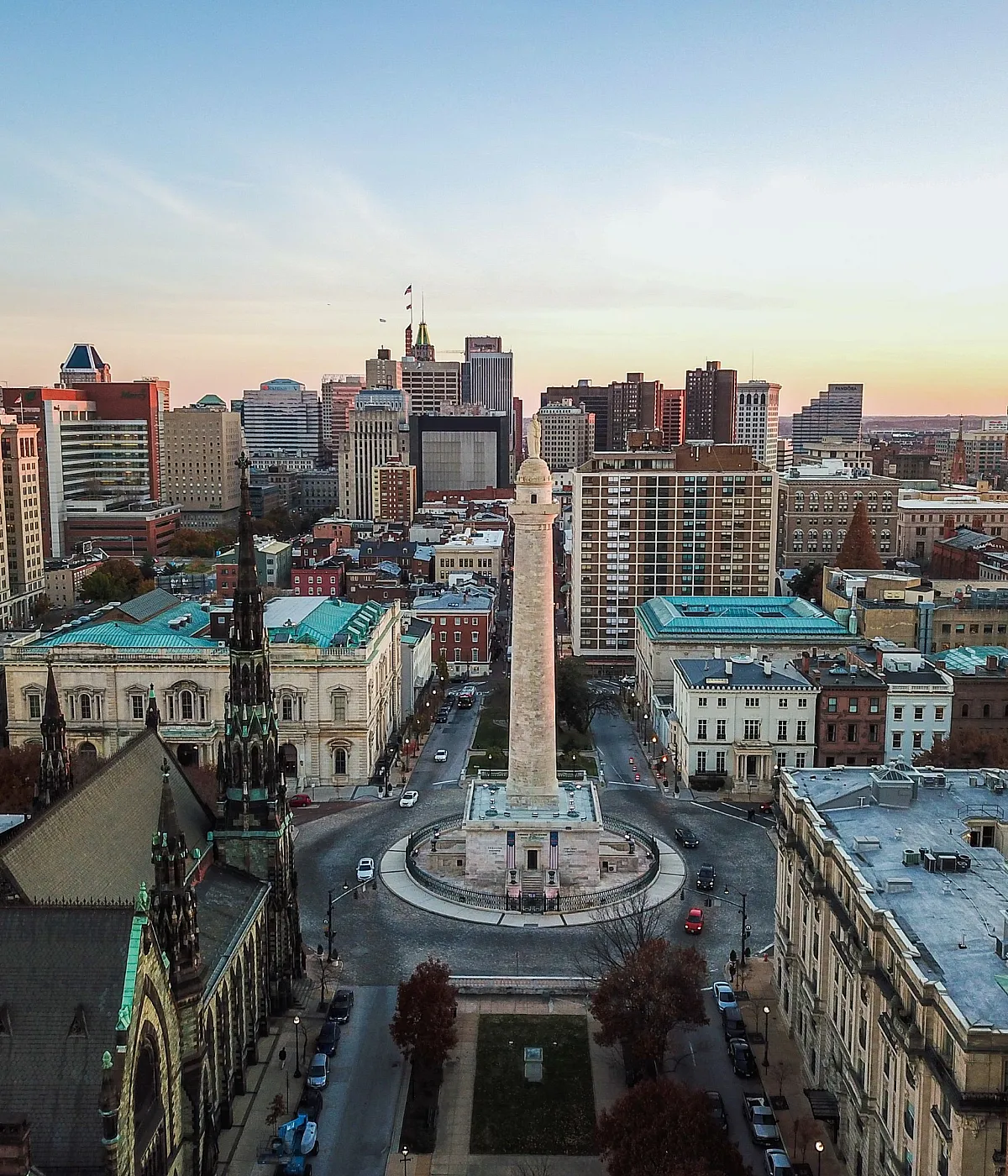 Breathtaking aerial view of a vibrant cityscape with historic architecture and a stunning sunset backdrop.