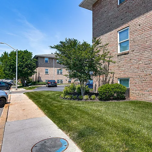 Charming exterior view of Sequoia Manor Apartments showcasing manicured lawns and convenient parking in a peaceful neighborhood.