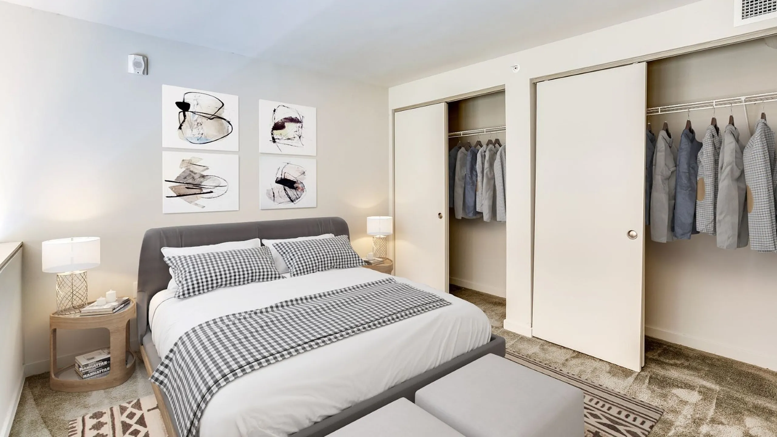 Elegant bedroom with a cozy double bed, stylish wall art, ample closet space, and modern bedside tables for sophisticated living.