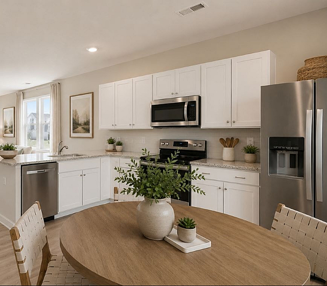 Bright open-plan living area with modern kitchen, elegant dining space, and cozy seating, flooded with natural light.
