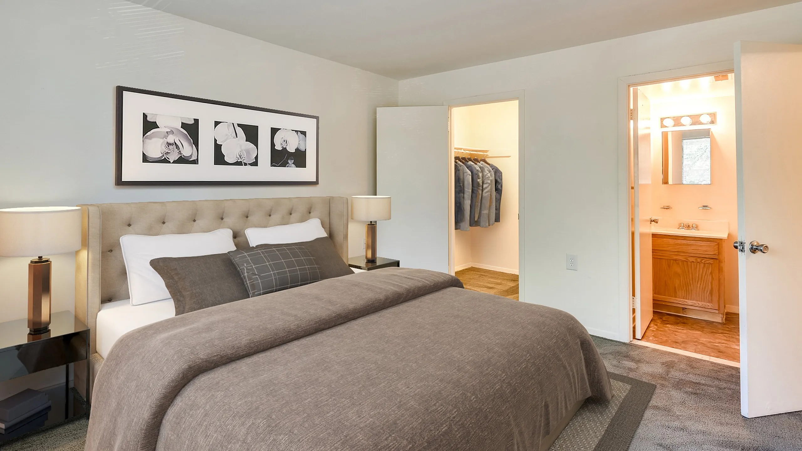 Cozy bedroom with a plush bed, elegant nightstands, and stylish wall art, featuring a walk-in closet and a modern en-suite bathroom.