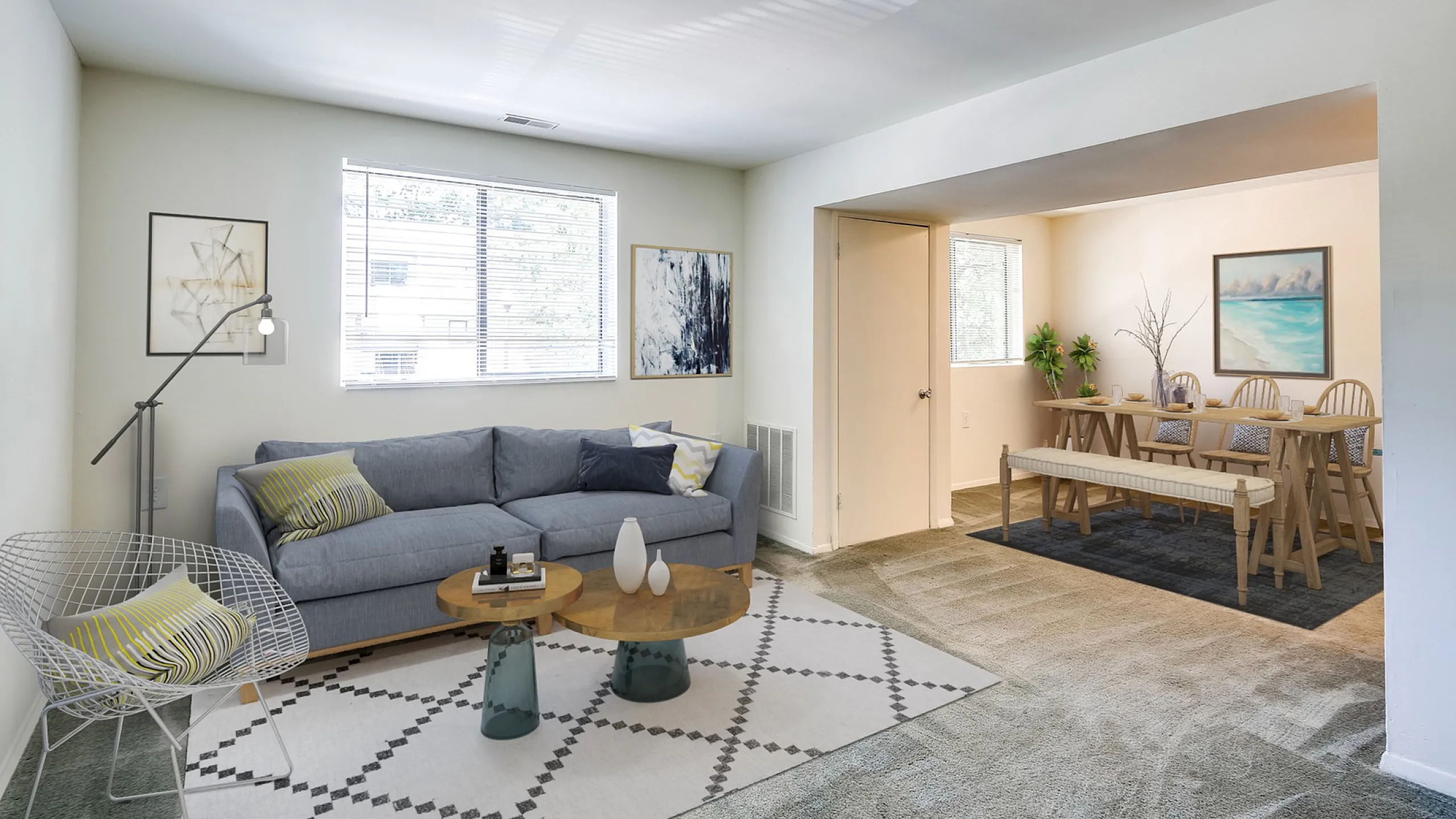 Modern living room with stylish gray sofa, chic decor, and bright dining area, creating an inviting and spacious atmosphere.