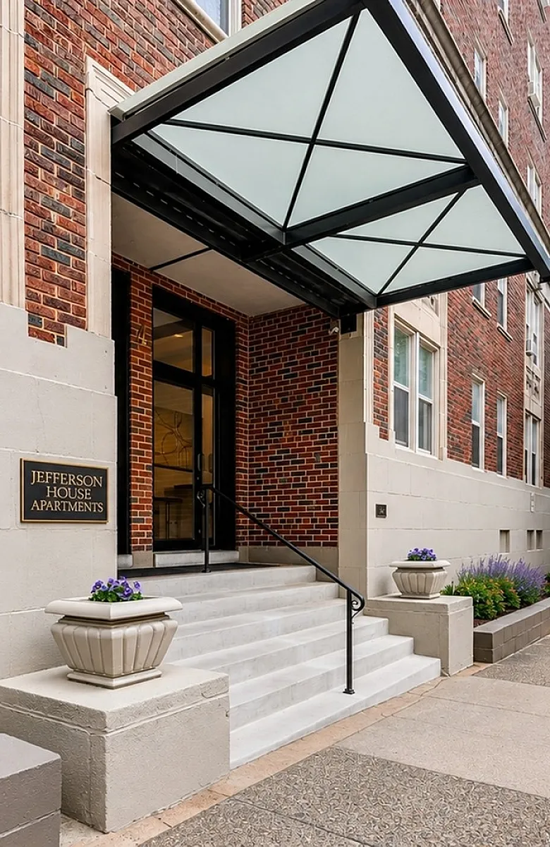 Charming entrance of Jefferson House Apartments with elegant canopy and inviting landscaping.