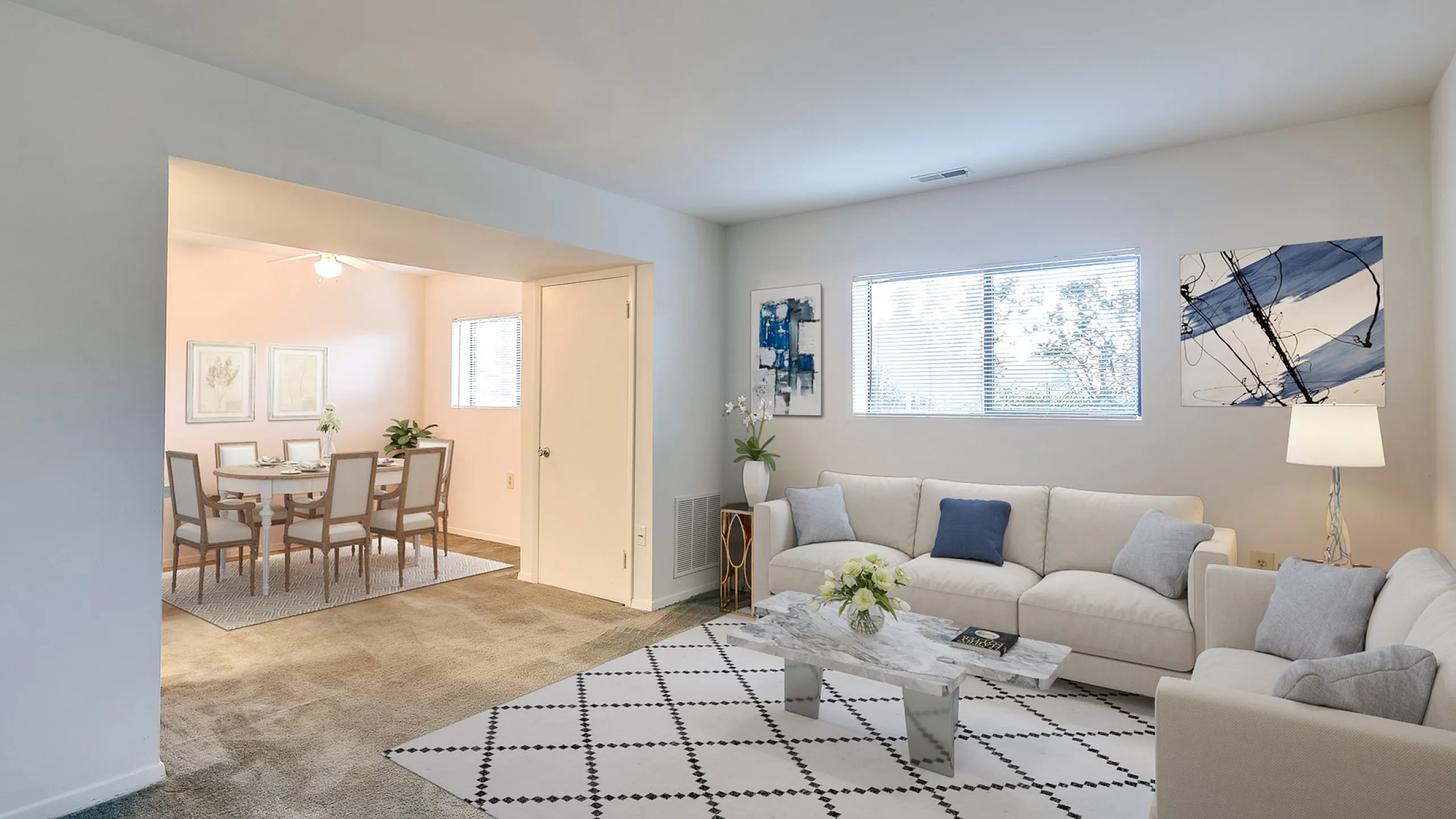 Elegant living and dining area in a modern apartment with a cozy white sofa, stylish decor, and large windows for natural light.