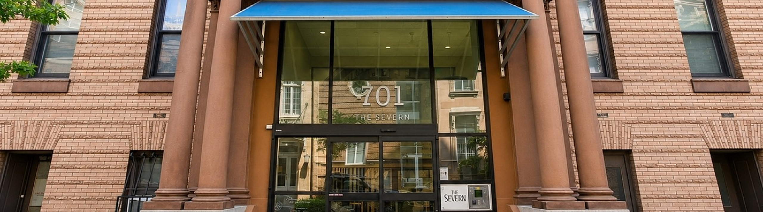 Elegant brick facade of The Severn with grand entrance and stately columns, showcasing timeless architectural charm.