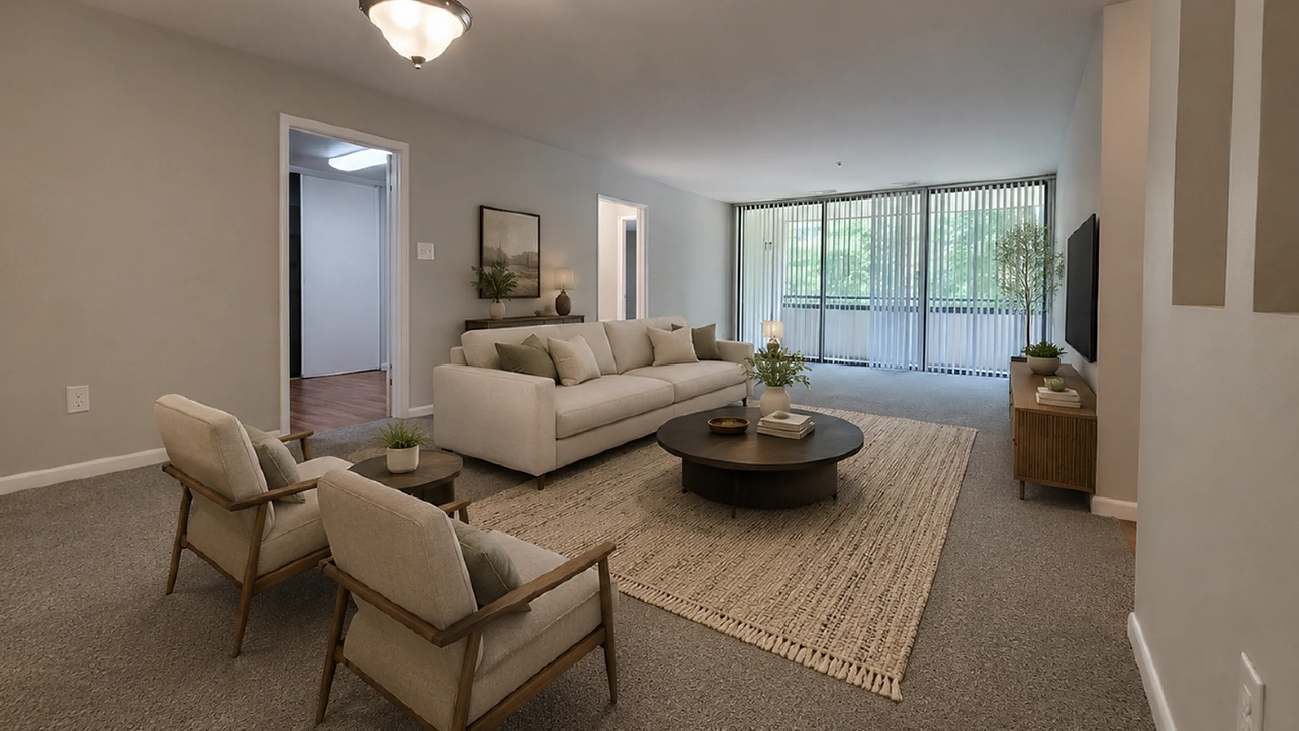 Inviting living room with modern decor, cozy seating, and expansive windows offering natural light and lush views.