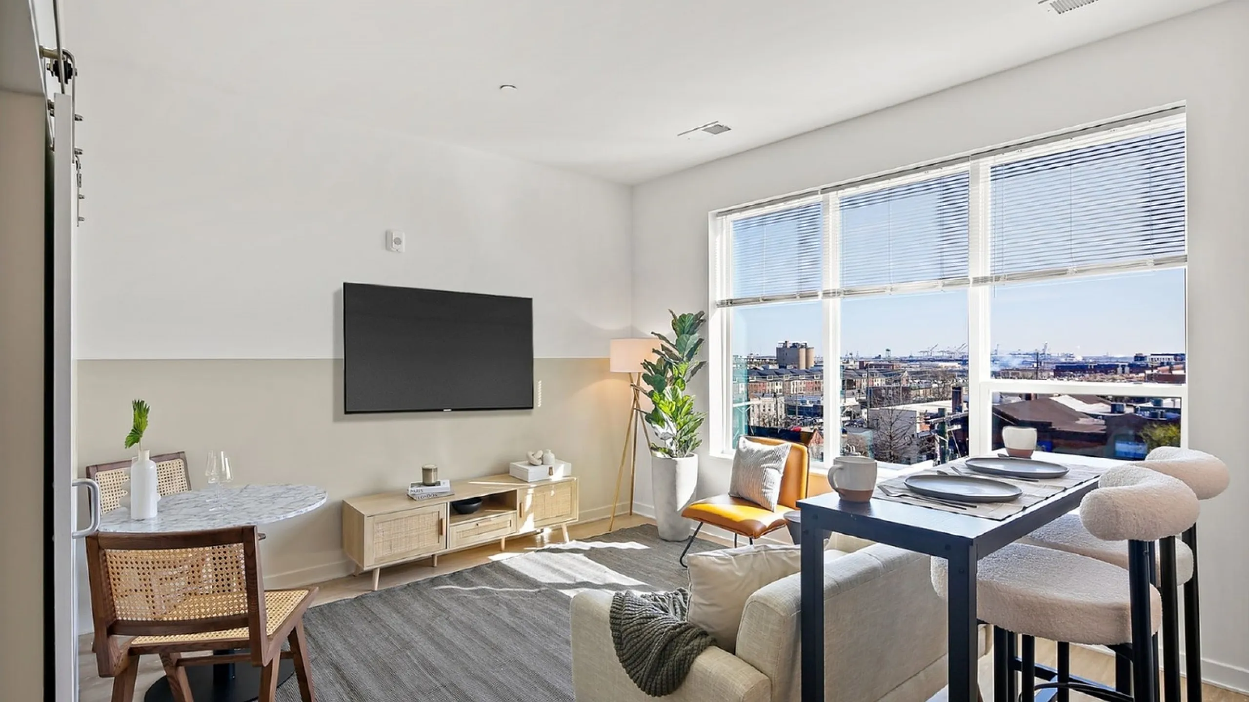 Bright and modern living space with large window views, stylish furniture, and cozy dining area.