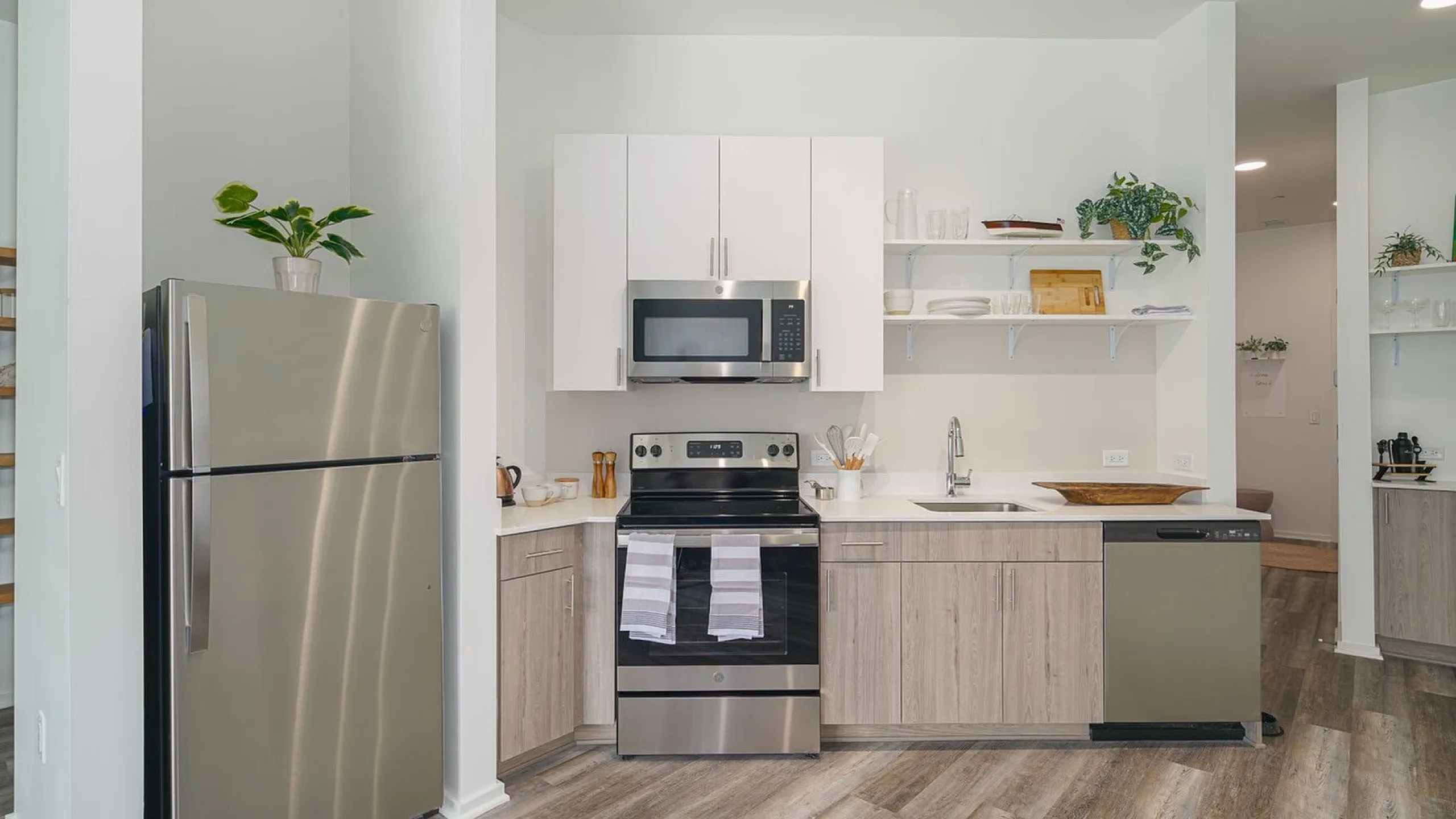 Modern kitchen with stainless steel appliances, sleek cabinetry, and open shelving for a stylish and functional design.