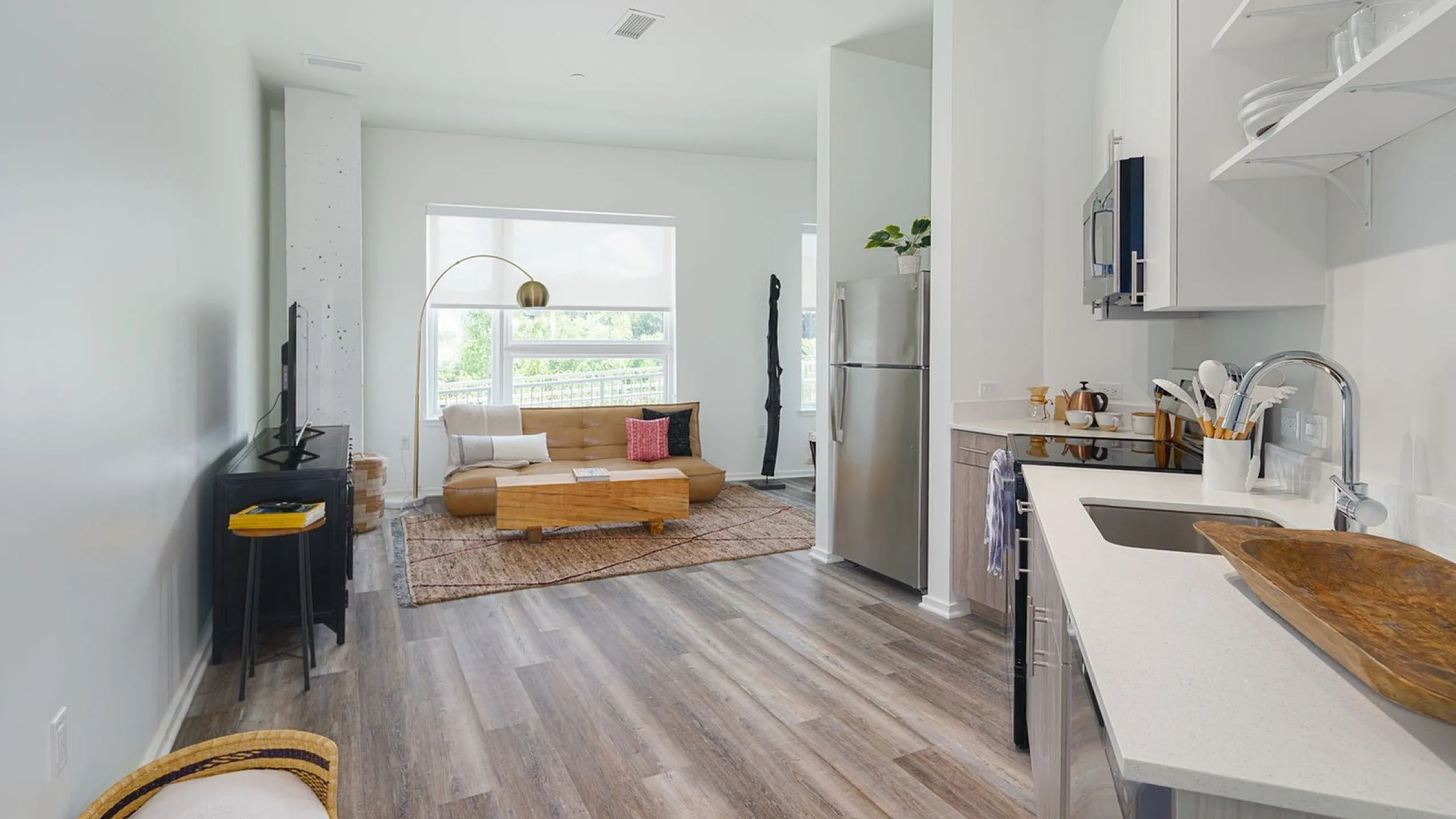 Chic open-plan apartment with elegant living area, stylish kitchen, and large window flooding the space with natural light.