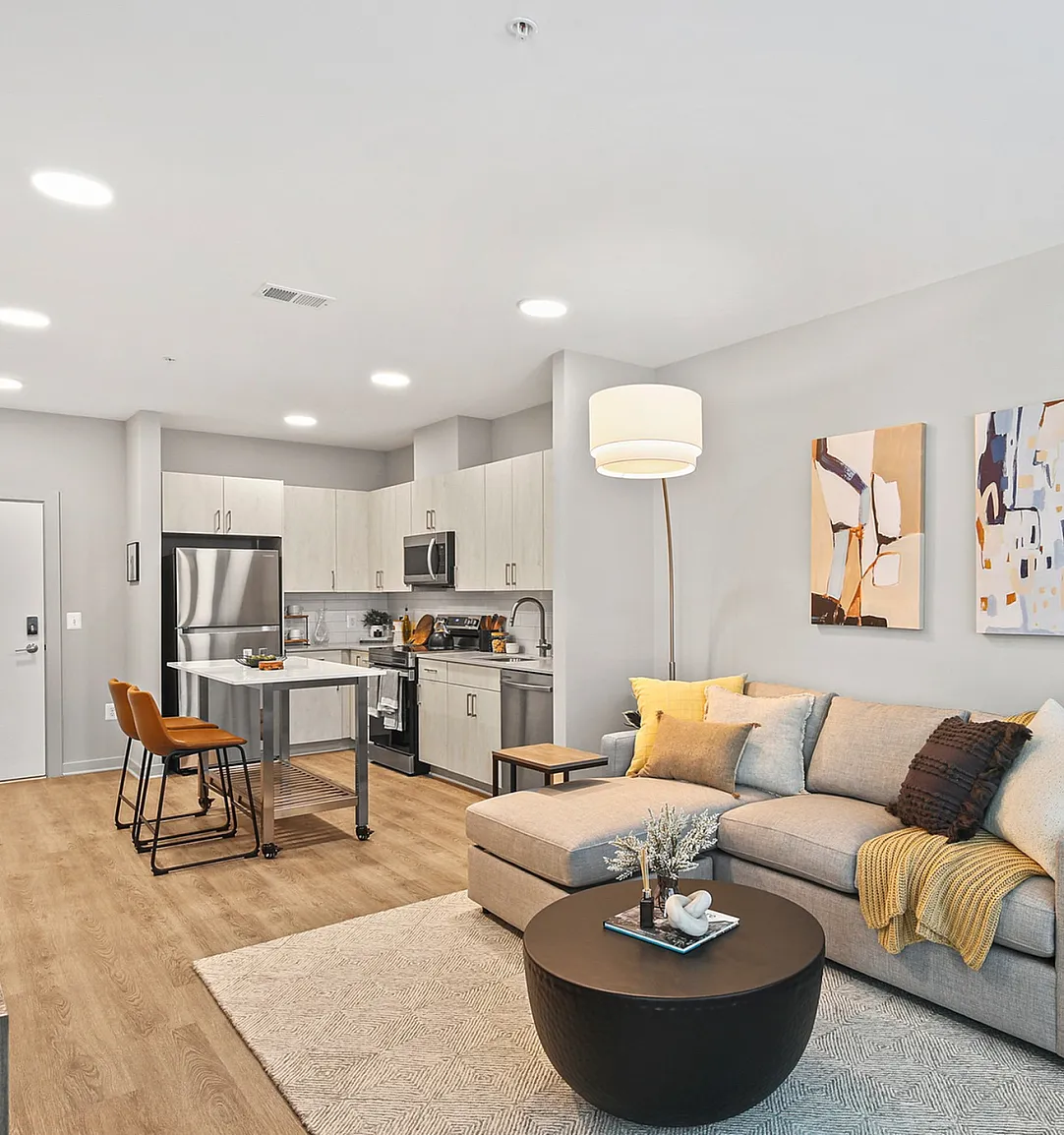 Chic open-concept apartment with modern kitchen, cozy living area, and stylish decor.