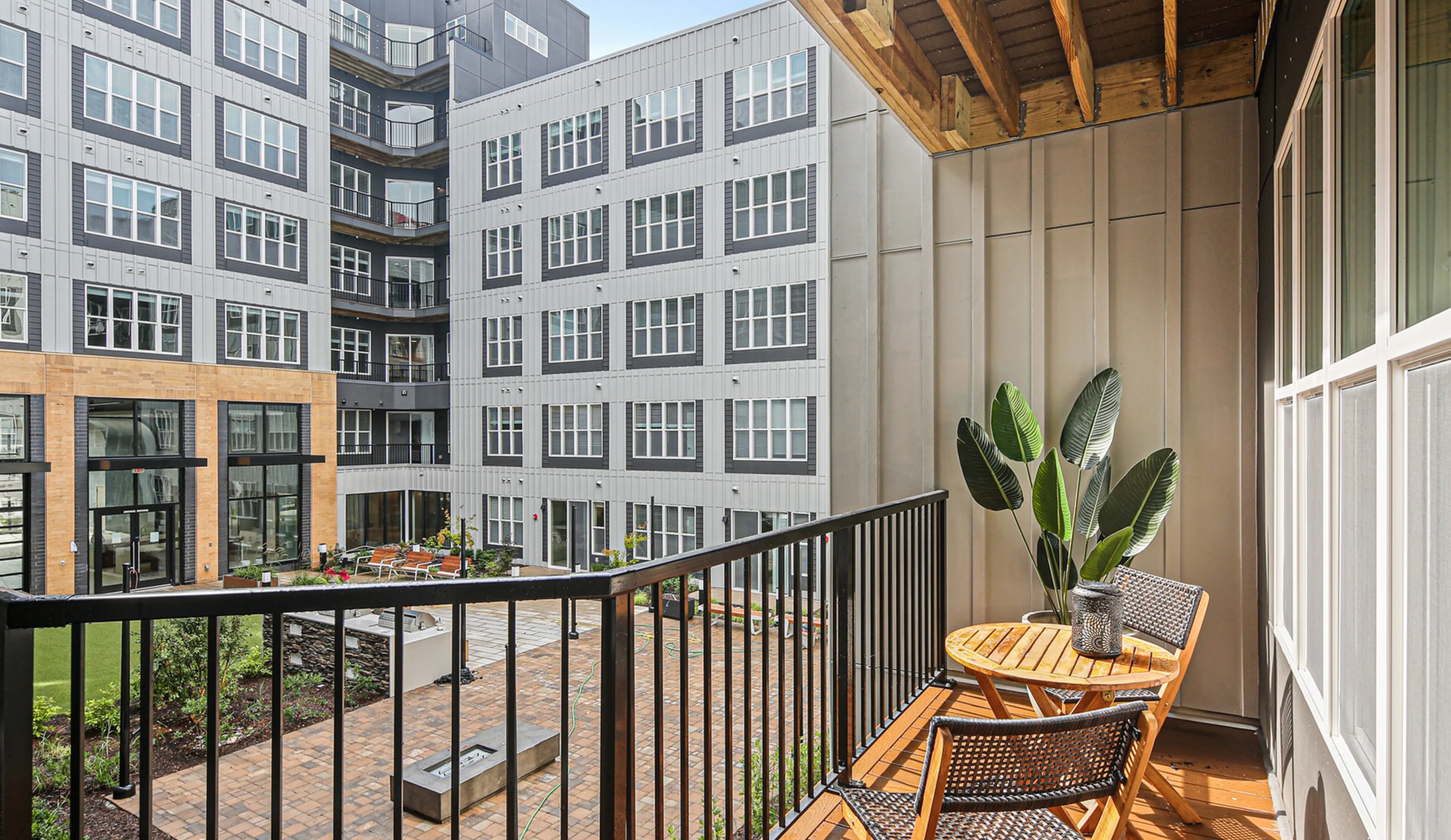 Chic balcony view overlooking a modern courtyard with stylish outdoor seating, perfect for relaxation and enjoying the urban ambience.