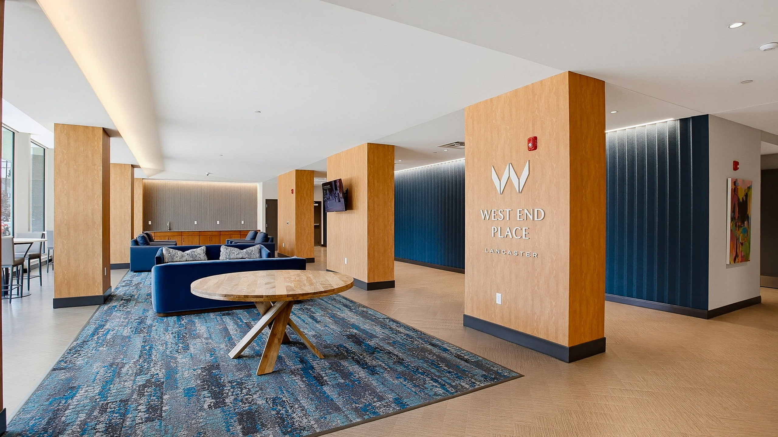 Modern lobby at West End Place Lancaster featuring sleek wooden accents, plush seating, and contemporary design.