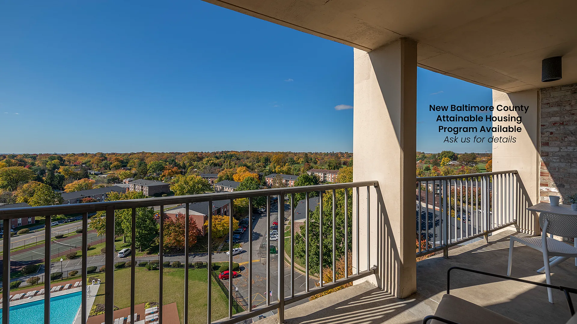Inviting balcony view showcasing lush greenery and sparkling pool in Baltimore County's attainable housing program.
