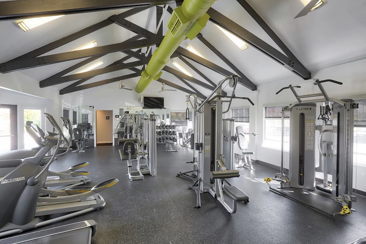 Modern fitness center with state-of-the-art exercise equipment, high ceilings, and abundant natural light for an invigorating workout environment.