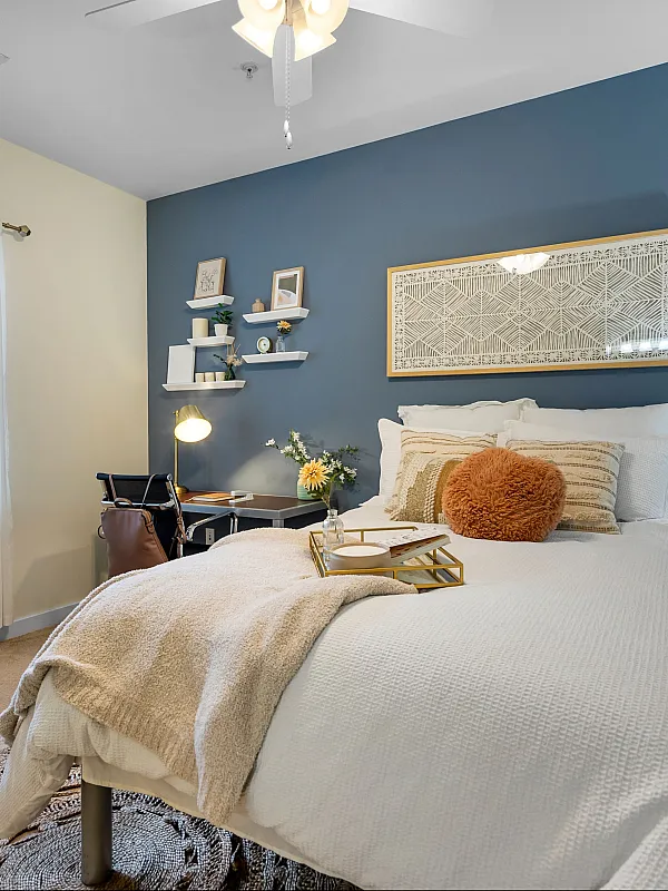 campus crossings briarcliff 2 bedroom model unit with full sized bed, desk, and end table.