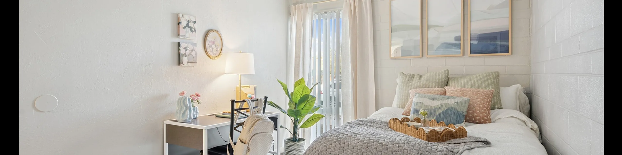 Cozy and bright bedroom with stylish decor, featuring a comfortable bed, chic desk space, and abundant natural light through large windows.